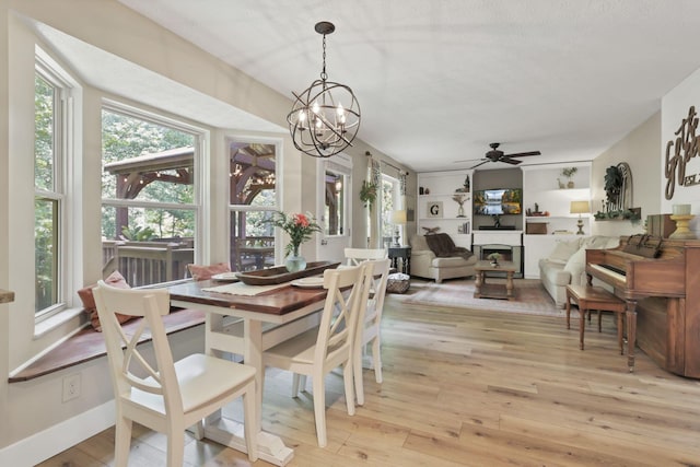 437 Barrington Rdg, Pataskala, OH 43062 - dining space featuring light wood finished floors, a chandelier, ceiling fan, and a fireplace