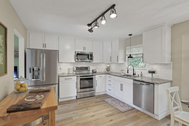 437 Barrington Rdg, Pataskala, OH 43062 - kitchen featuring appliances with stainless steel finishes, white cabinetry, light stone countertops, and a textured ceiling