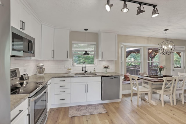 437 Barrington Rdg, Pataskala, OH 43062 - kitchen featuring stainless steel appliances, white cabinetry, light wood-style floors, tasteful backsplash, and a textured ceiling