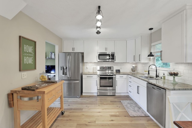 437 Barrington Rdg, Pataskala, OH 43062 - kitchen with appliances with stainless steel finishes, light stone counters, white cabinets, backsplash, and light wood-style flooring