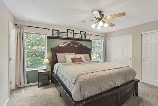 437 Barrington Rdg, Pataskala, OH 43062 - carpeted bedroom featuring multiple windows, multiple closets, a textured ceiling, and ceiling fan