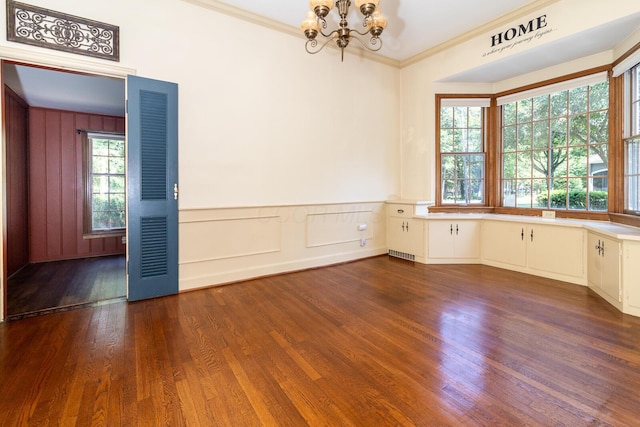 670 Greenwich St, Worthington, OH 43085 - empty room featuring a chandelier, dark wood-style floors, ornamental molding, a decorative wall, and a wainscoted wall