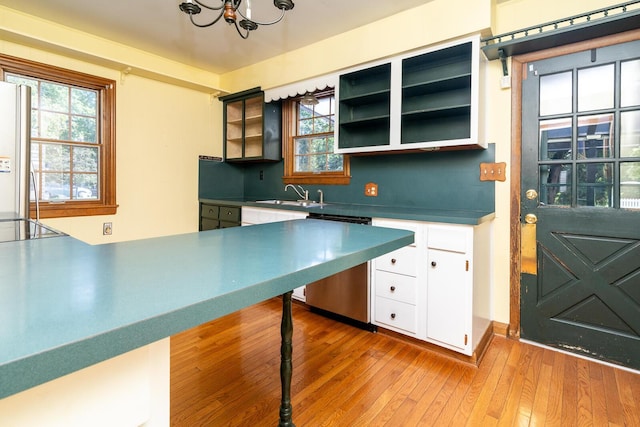 670 Greenwich St, Worthington, OH 43085 - kitchen with stainless steel dishwasher, light wood-type flooring, a chandelier, white cabinetry, and freestanding refrigerator
