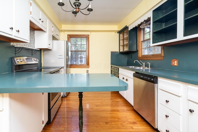 670 Greenwich St, Worthington, OH 43085 - kitchen featuring stainless steel appliances, a chandelier, light wood-style flooring, white cabinetry, and dark countertops