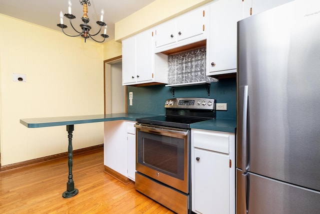 670 Greenwich St, Worthington, OH 43085 - kitchen with appliances with stainless steel finishes, light wood-style flooring, dark countertops, white cabinetry, and a chandelier