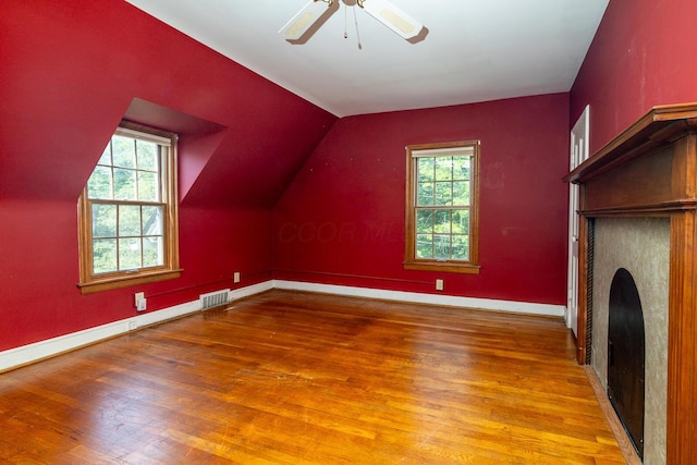 670 Greenwich St, Worthington, OH 43085 - additional living space with wood finished floors, healthy amount of natural light, lofted ceiling, a fireplace, and a ceiling fan