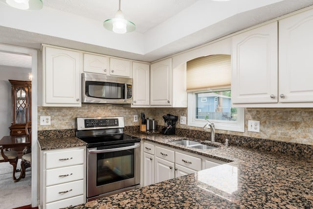 2740 Mitzi Dr, Columbus, OH 43209 - kitchen featuring stainless steel appliances, dark stone countertops, white cabinets, and backsplash
