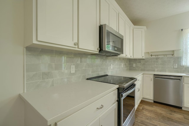 3663 Cedar Hill Rd NW, Canal Winchester, OH 43110 - kitchen featuring appliances with stainless steel finishes, light countertops, white cabinets, dark wood-type flooring, and a textured ceiling