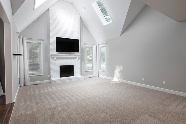 833 Moon Glow Ct, Columbus, OH 43230 - unfurnished living room with a skylight, a brick fireplace, carpet floors, and high vaulted ceiling