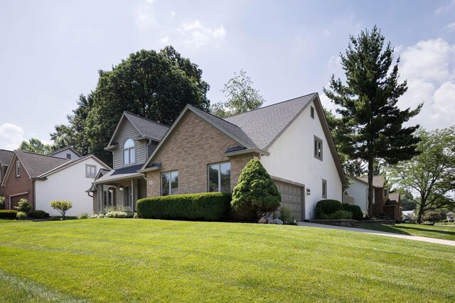 833 Moon Glow Ct, Columbus, OH 43230 - view of front facade with a garage, brick siding, a front yard, and stucco siding