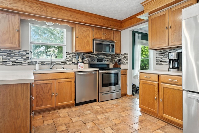 1126 Welwyn Dr, Westerville, OH 43081 - kitchen with stainless steel appliances, tasteful backsplash, light countertops, a textured ceiling, and brown cabinets