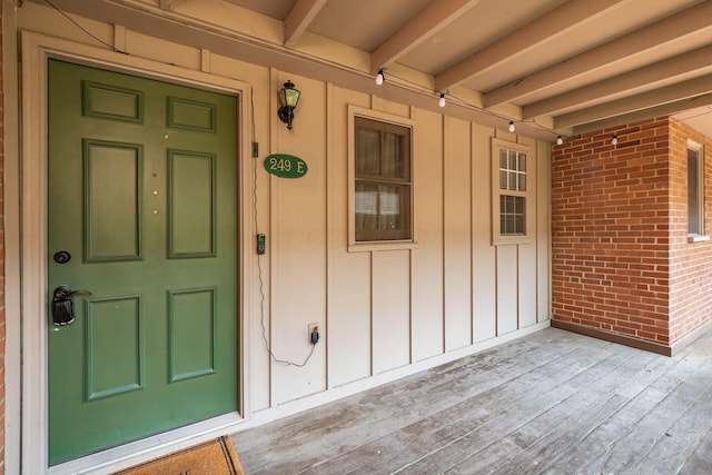 249 E Kossuth St Unit E, Columbus, OH 43206 - doorway to property featuring covered porch, board and batten siding, and brick siding