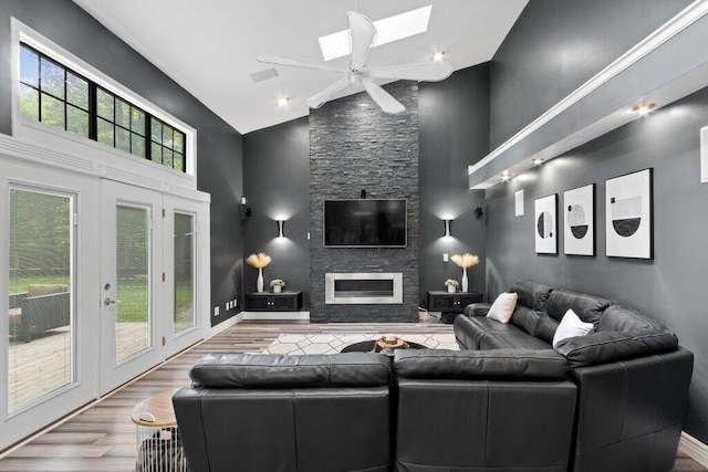 10382 Wright Rd NW, Canal Winchester, OH 43110 - living area with high vaulted ceiling, a skylight, wood finished floors, a fireplace, and ceiling fan