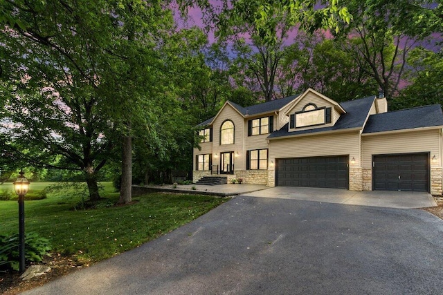 10382 Wright Rd NW, Canal Winchester, OH 43110 - view of front of house with asphalt driveway, stone siding, an attached garage, a front lawn, and a chimney