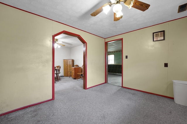 412 E Mill St, Circleville, OH 43113 - empty room with a ceiling fan, a textured ceiling, carpet flooring, and arched walkways