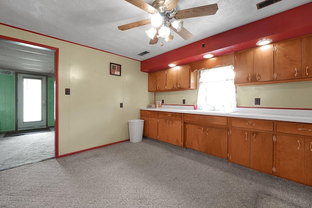 412 E Mill St, Circleville, OH 43113 - kitchen featuring light carpet, brown cabinets, light countertops, a textured ceiling, and ceiling fan