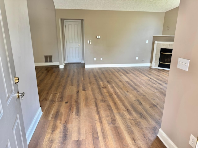 6608 Lakeview Cir, Canal Winchester, OH 43110 - unfurnished living room featuring wood finished floors, a tile fireplace, and a textured ceiling