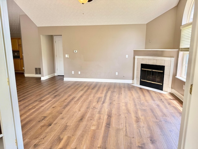 6608 Lakeview Cir, Canal Winchester, OH 43110 - unfurnished living room with vaulted ceiling, wood finished floors, a textured ceiling, and a fireplace