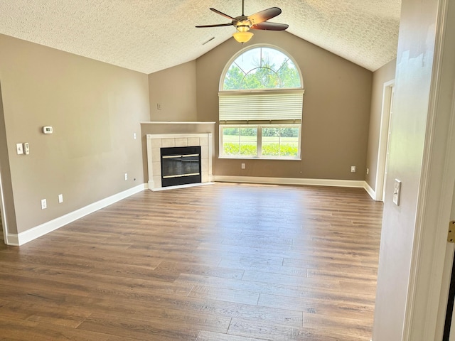 6608 Lakeview Cir, Canal Winchester, OH 43110 - unfurnished living room with a ceiling fan, lofted ceiling, a textured ceiling, wood finished floors, and a tile fireplace