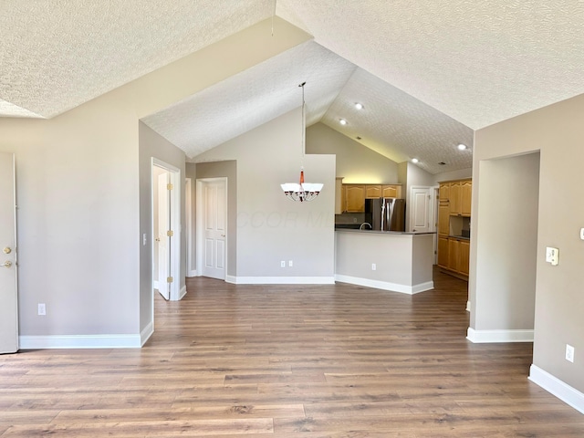 6608 Lakeview Cir, Canal Winchester, OH 43110 - unfurnished living room with vaulted ceiling, a textured ceiling, a chandelier, wood finished floors, and recessed lighting