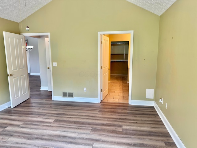 6608 Lakeview Cir, Canal Winchester, OH 43110 - unfurnished bedroom with lofted ceiling, a textured ceiling, wood finished floors, a spacious closet, and a closet