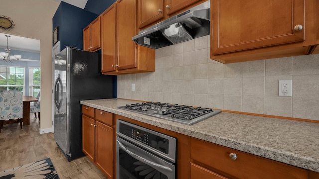 6229 Janes Way, Hilliard, OH 43026 - kitchen with extractor fan, appliances with stainless steel finishes, brown cabinets, light wood-type flooring, and light countertops