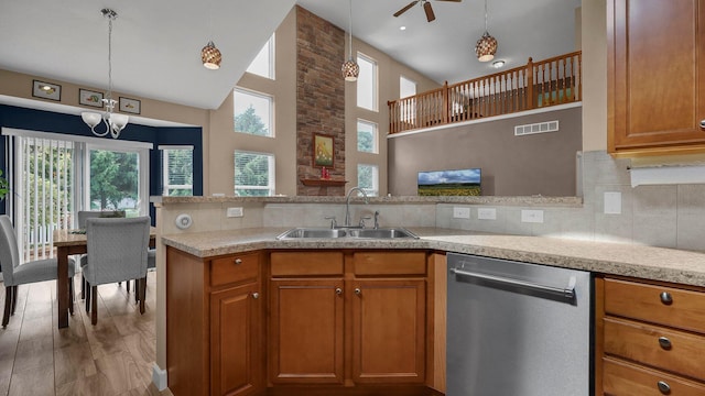 6229 Janes Way, Hilliard, OH 43026 - kitchen with stainless steel dishwasher, brown cabinetry, ceiling fan, decorative light fixtures, and a towering ceiling