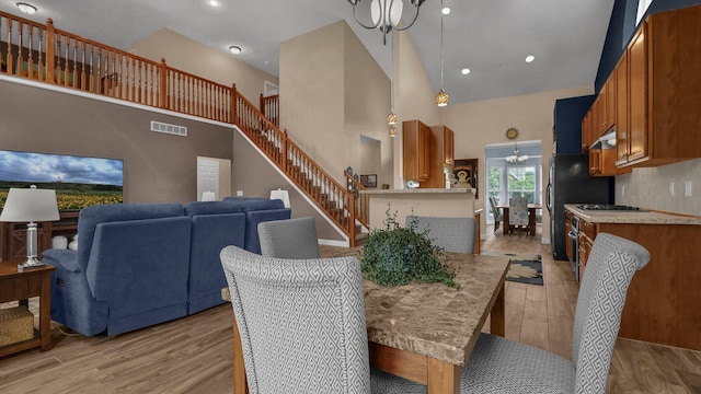 6229 Janes Way, Hilliard, OH 43026 - dining space with a chandelier, high vaulted ceiling, light wood finished floors, and recessed lighting
