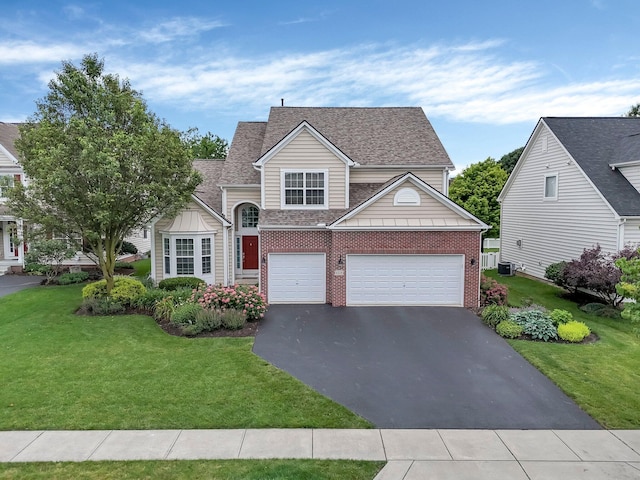 6229 Janes Way, Hilliard, OH 43026 - traditional home with asphalt driveway, brick siding, a front yard, an attached garage, and roof with shingles