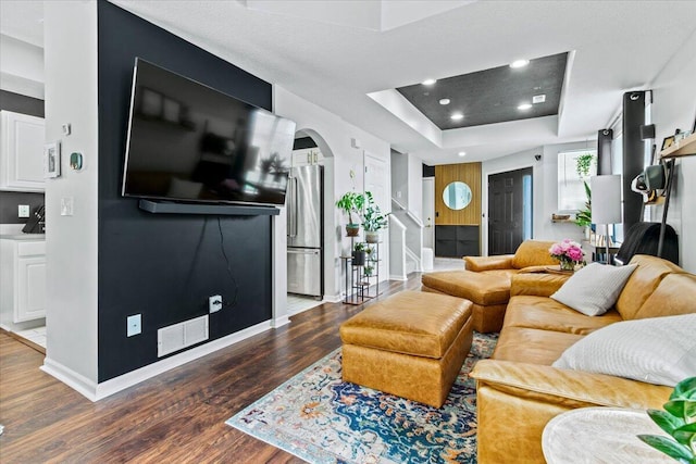 5821 Albany Grv, Westerville, OH 43081 - living area featuring arched walkways, a raised ceiling, wood finished floors, stairway, and recessed lighting