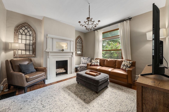 336 E Kossuth St, Columbus, OH 43206 - living room with wood finished floors, a chandelier, and a fireplace