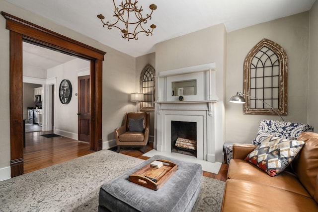 336 E Kossuth St, Columbus, OH 43206 - living area with a fireplace with flush hearth, wood finished floors, and a chandelier