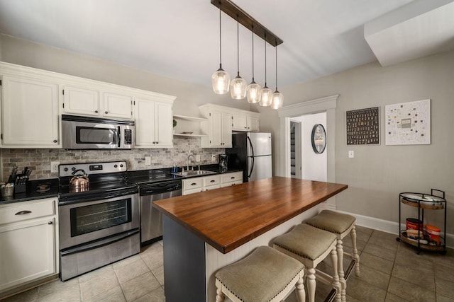 336 E Kossuth St, Columbus, OH 43206 - kitchen with appliances with stainless steel finishes, wood counters, backsplash, and light tile patterned floors