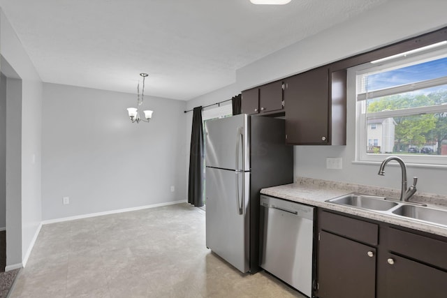 7607-7609 Penwood Pl, Columbus, OH 43235 - kitchen featuring stainless steel appliances, a chandelier, light countertops, dark brown cabinets, and pendant lighting