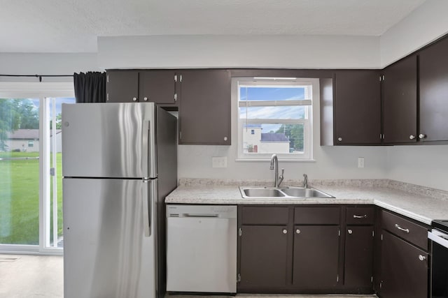 7607-7609 Penwood Pl, Columbus, OH 43235 - kitchen with appliances with stainless steel finishes, light countertops, healthy amount of natural light, dark brown cabinetry, and a textured ceiling