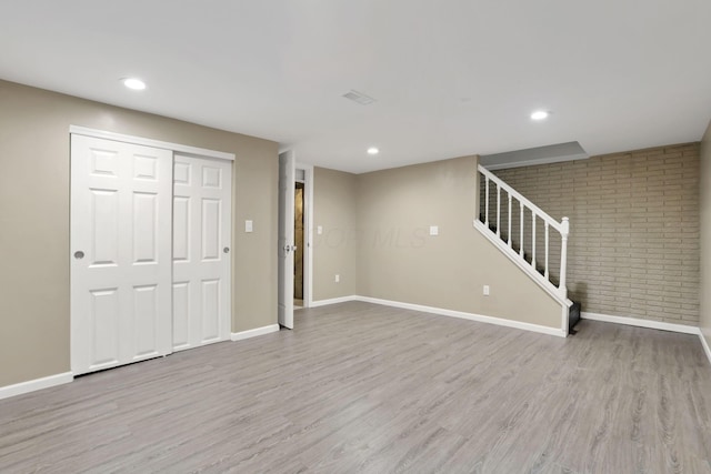 7607-7609 Penwood Pl, Columbus, OH 43235 - finished below grade area with wood finished floors, stairs, recessed lighting, and brick wall