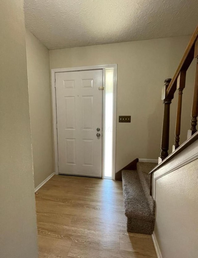 7607-7609 Penwood Pl, Columbus, OH 43235 - entrance foyer featuring stairway, wood finished floors, and a textured ceiling