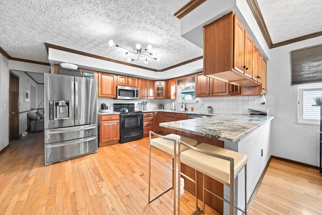 505 Tresham Rd, Columbus, OH 43230 - kitchen with appliances with stainless steel finishes, ornamental molding, brown cabinets, a peninsula, and light wood-type flooring