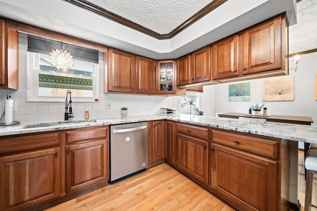 505 Tresham Rd, Columbus, OH 43230 - kitchen with stainless steel dishwasher, a peninsula, light wood-style flooring, brown cabinets, and light stone countertops