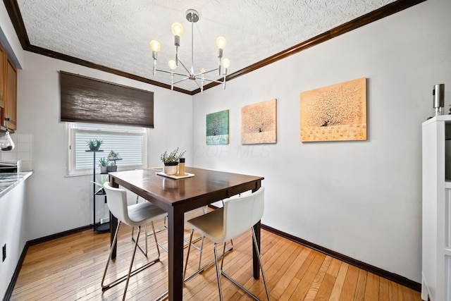 505 Tresham Rd, Columbus, OH 43230 - dining area featuring light wood finished floors, a chandelier, a textured ceiling, and crown molding