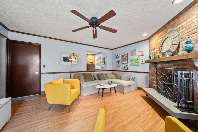 505 Tresham Rd, Columbus, OH 43230 - living room featuring wood finished floors, a ceiling fan, a textured ceiling, a brick fireplace, and ornamental molding