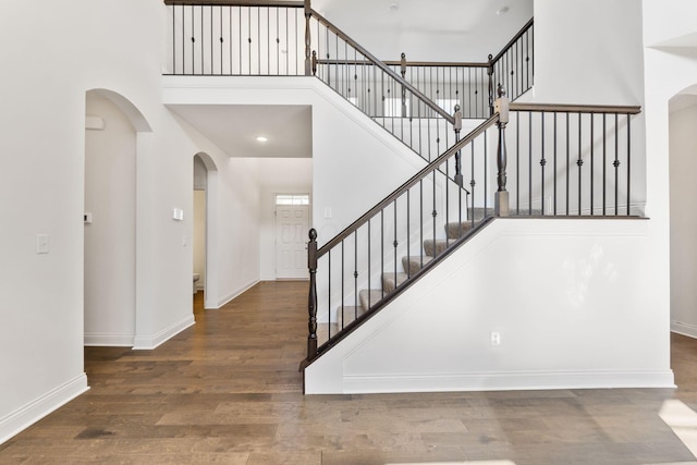 3622 Switchgrass Ct, Hilliard, OH 43026 - staircase featuring arched walkways, a high ceiling, and wood finished floors