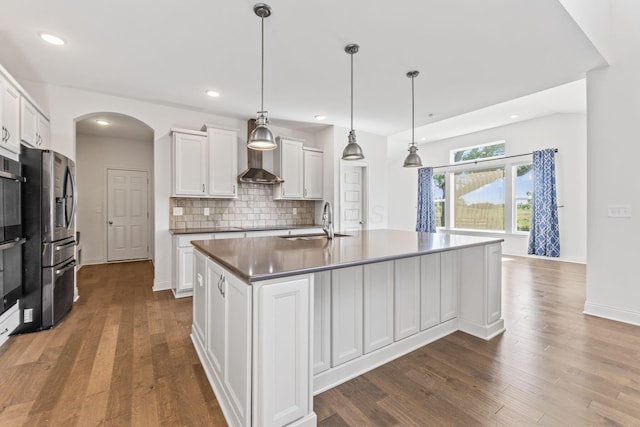 3622 Switchgrass Ct, Hilliard, OH 43026 - kitchen featuring arched walkways, white cabinetry, dark wood-type flooring, stainless steel fridge, and tasteful backsplash