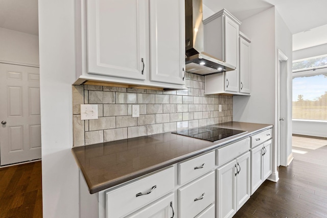 3622 Switchgrass Ct, Hilliard, OH 43026 - kitchen with wall chimney range hood, black electric cooktop, dark wood finished floors, and backsplash