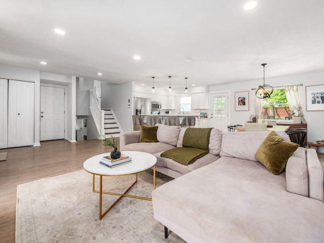 5611 Donnally Ct, Dublin, OH 43016 - living area with stairs, light wood-style floors, recessed lighting, healthy amount of natural light, and a chandelier