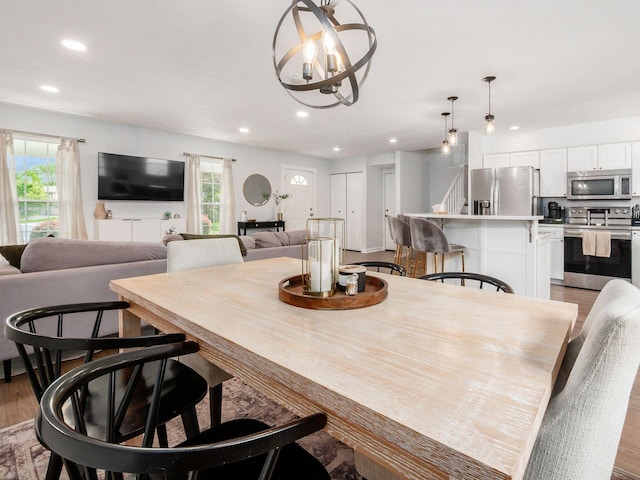 5611 Donnally Ct, Dublin, OH 43016 - dining space with recessed lighting, wood finished floors, a chandelier, and stairs