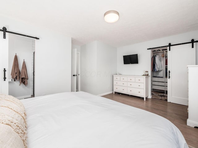 5611 Donnally Ct, Dublin, OH 43016 - bedroom featuring a barn door, wood finished floors, a closet, and a walk in closet
