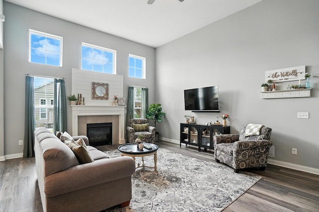 618 Ludham Trl, Pickerington, OH 43147 - living area featuring a tiled fireplace, wood finished floors, a ceiling fan, and a towering ceiling