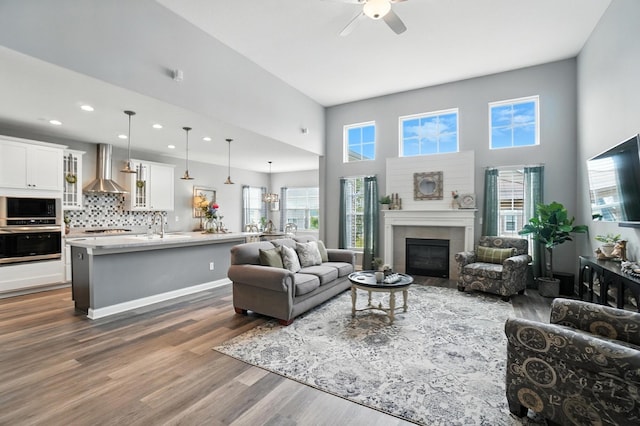 618 Ludham Trl, Pickerington, OH 43147 - living area featuring a ceiling fan, dark wood-style flooring, a tile fireplace, recessed lighting, and a towering ceiling