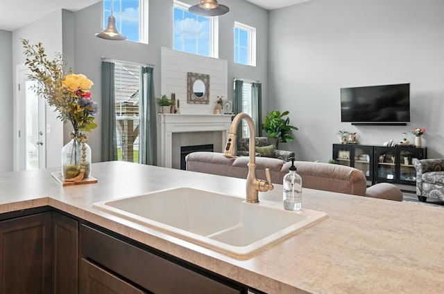 618 Ludham Trl, Pickerington, OH 43147 - kitchen with open floor plan, dark brown cabinets, a fireplace, light countertops, and hanging light fixtures